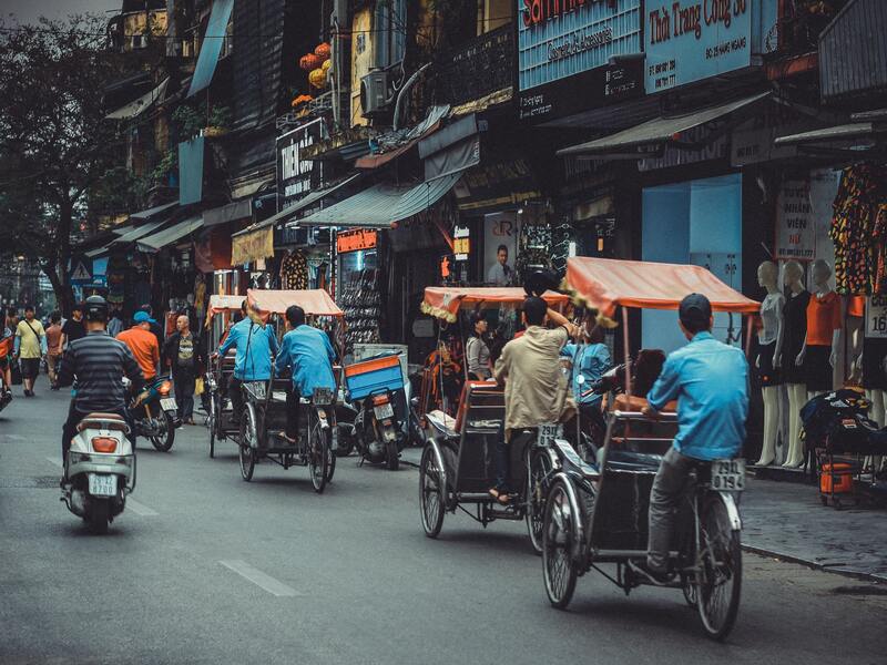 Groupe d'habitants se déplaçant en moto et en tricycle au Vietnam.