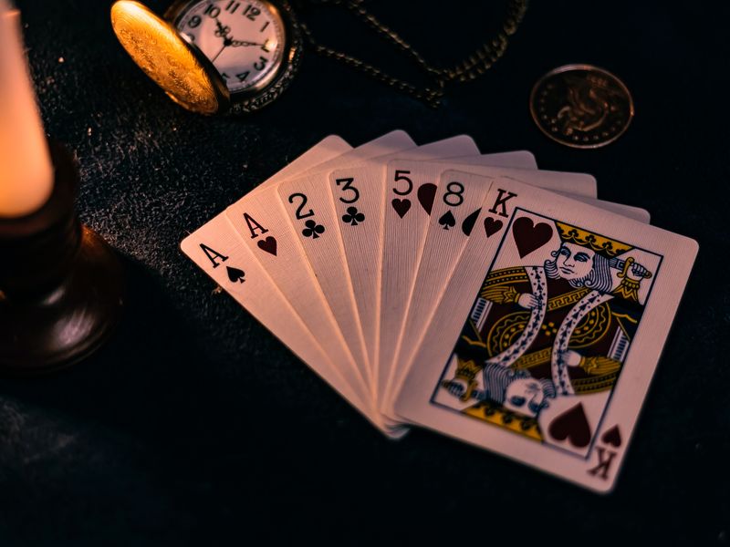 Cette image montre un jeu de cartes sur une table sombre.