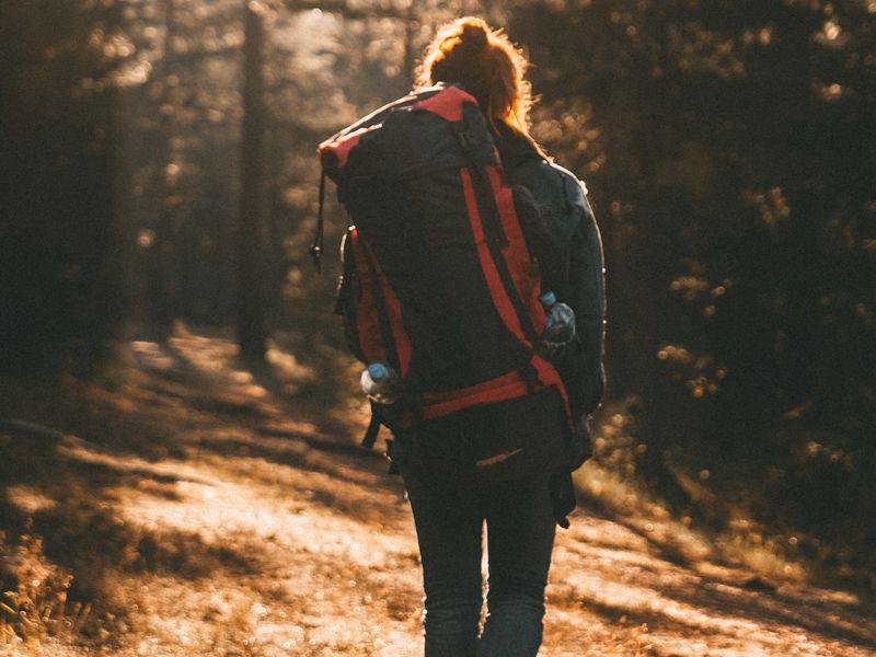 L'ascension du Slieve Donard est un défi relatif. Cette image montre une fille avec un gros sac à dos qui fait une randonnée dans une forêt.