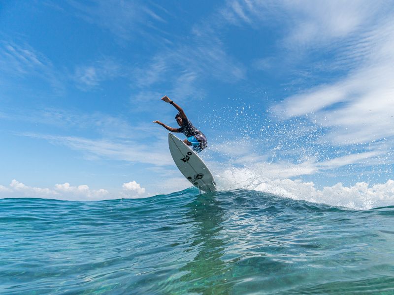 Une photo basse d'un surfeur dans les airs sur une vague. Playa Grande offre un excellent surf au Costa Rica pour les débutants.