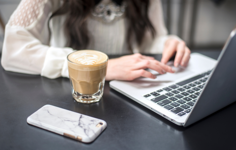 femme avec café joue sur ordinateur